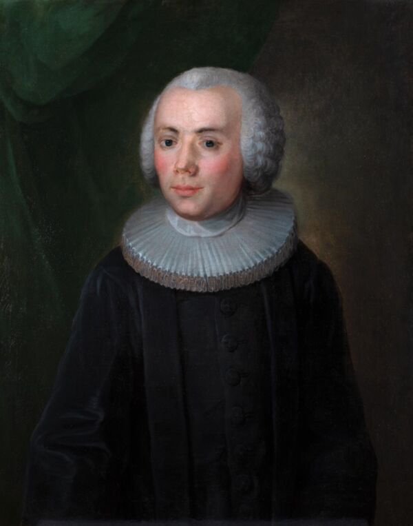 Mann i 1600-tallsbekledning med prestekjortel og grå parykk. Foto av maleri.