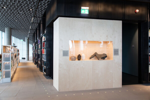 Foto av et skap i Deichman Bjørvika fylt med deler av kunstverk.