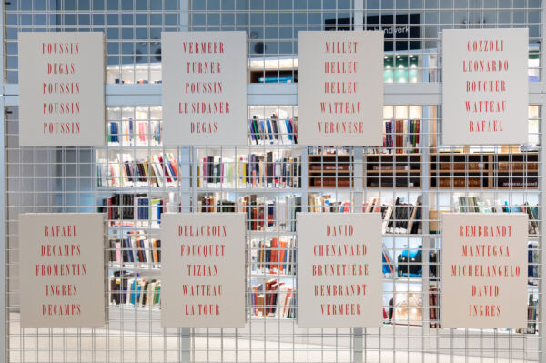 Foto av kunstverk hengende på et gjerde i Deichman Bjørvika.