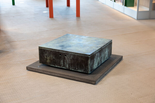 Foto av en skulptur formet som en sokkel stående på et gulv.