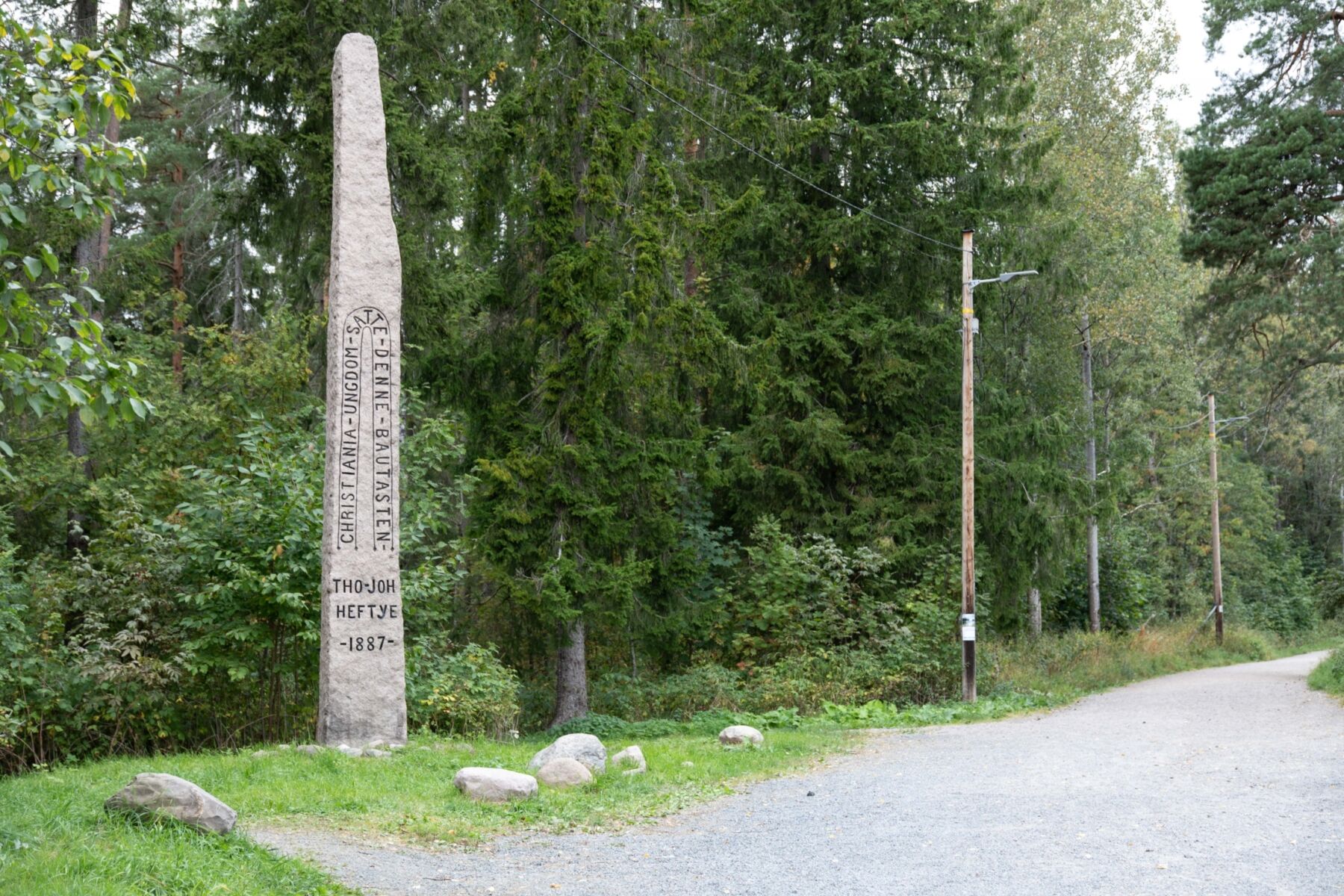 Bauta i veikanten med skog i bakgrunnen ved Midtstuen. Foto