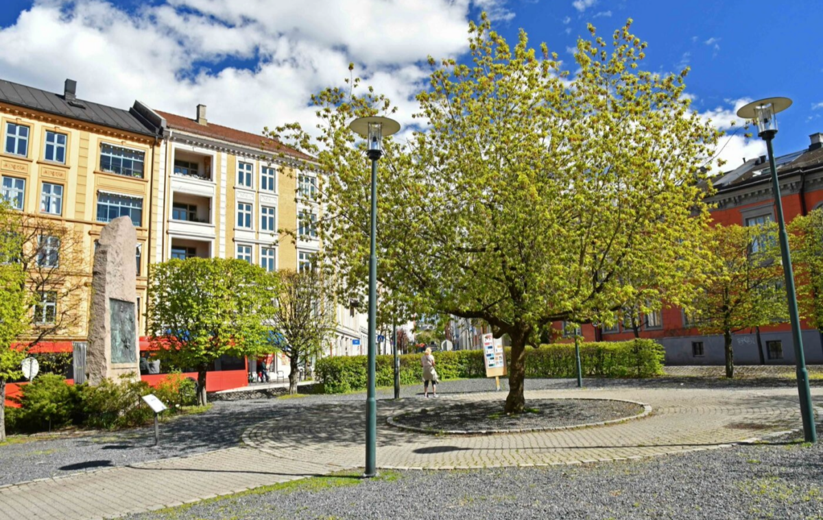 Et bytorg fylt med trær og bauta. Foto.