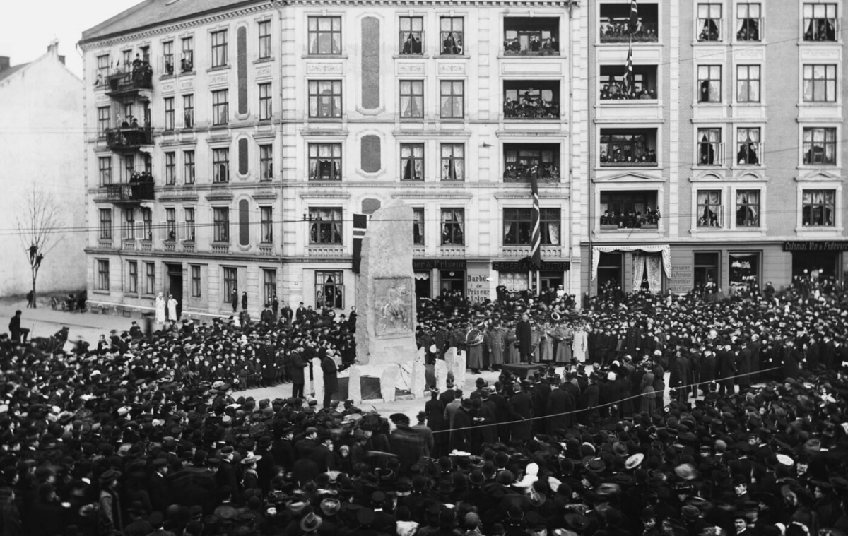 Svart-hvitt foto av en stor menneskemengde som er kommet for å se avdukingen av en bauta i Gamlebyen i Oslo.
