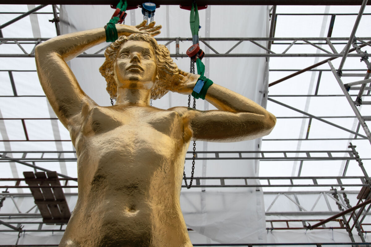 En gullforgylt statue av en kvinne, utsnitt, viser torso. Foto