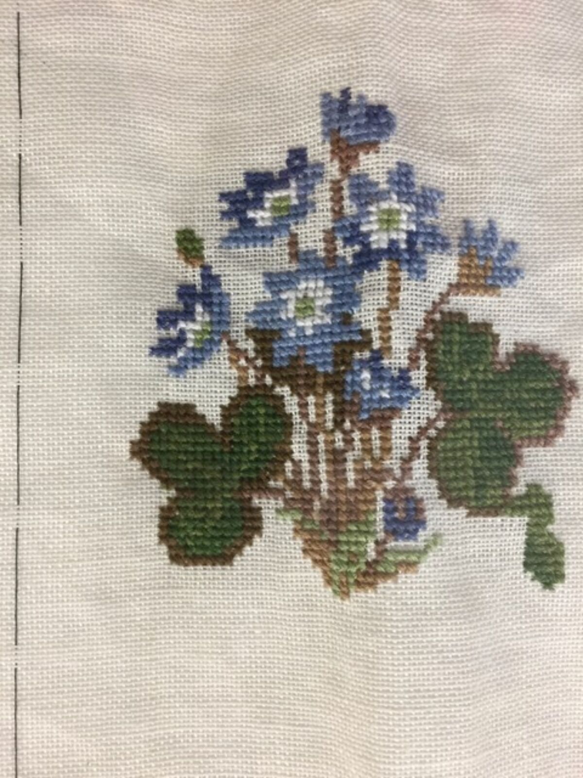 Broderi av blå blomst. Foto.