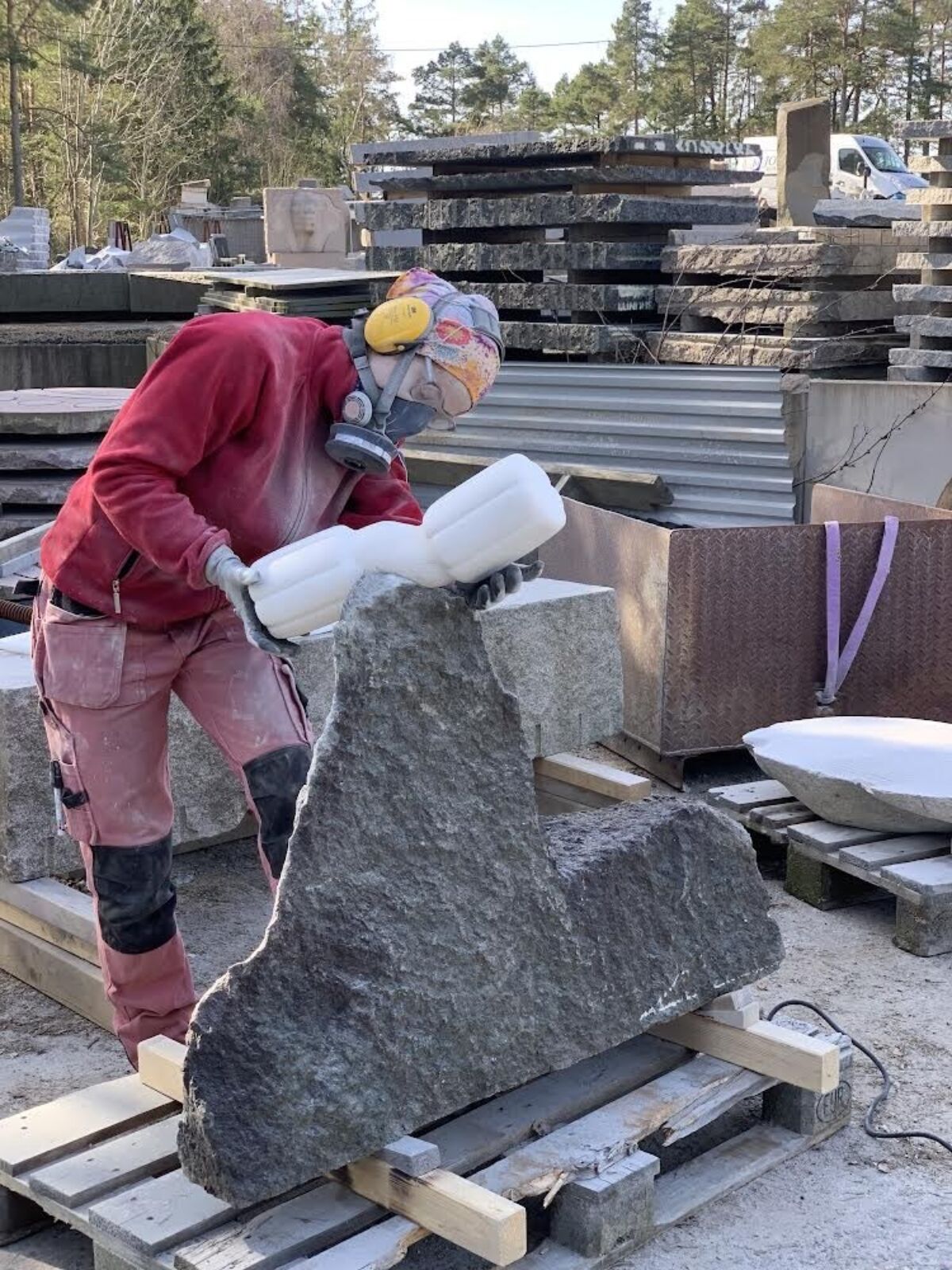Person jobber med steinskulptur. Foto.