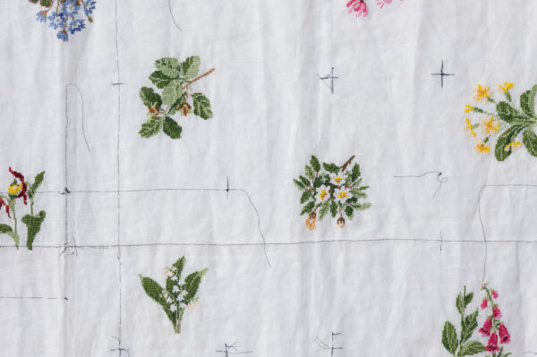 Nærbilde av broderi hengende på vegg i Furuset hageby.