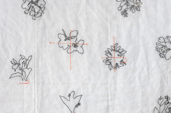 Nærbilde av broderi hengende på vegg i Furuset hageby.