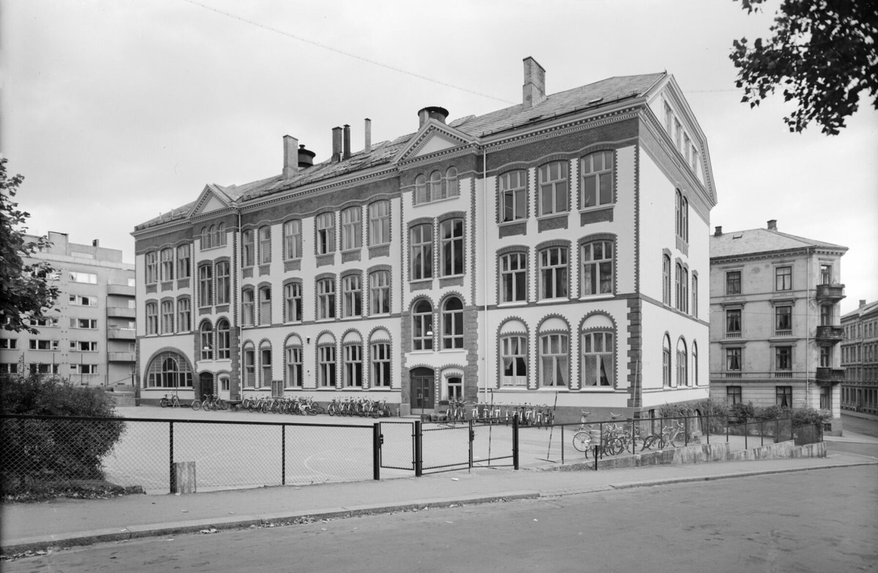 Svart-hvit foto av Hartvig Nissens skole med skolegården foran.