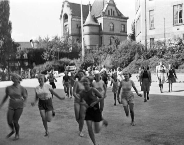 Mange jenter løper i skolegården til Hartvig Nissens skole. Foto.