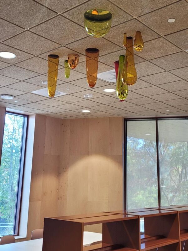Glassblåste former hengende i taket på en skole.