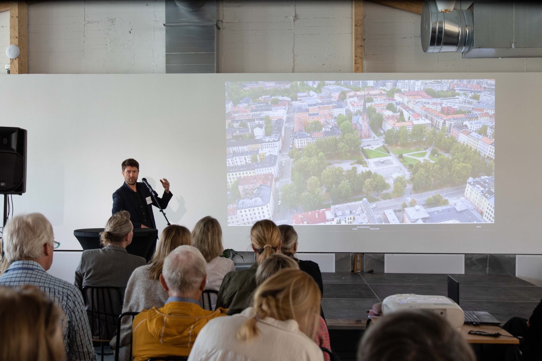 Person står på scene og holder presentasjon