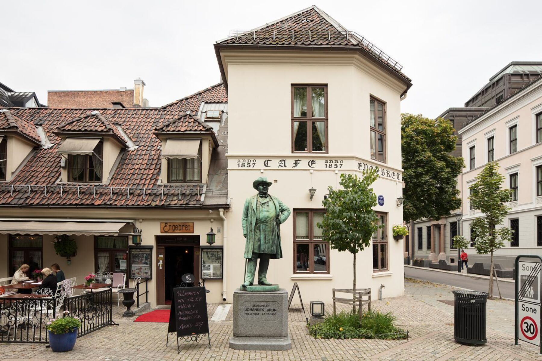 Bankplassen med skulptur og restaurant i bakgrunnen. Foto