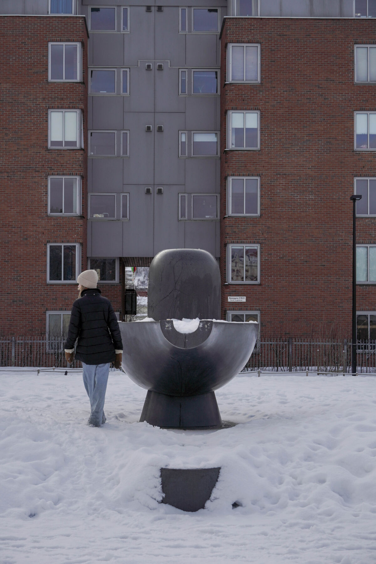 Barn går forbi en stor skulptur i en park. Foto.