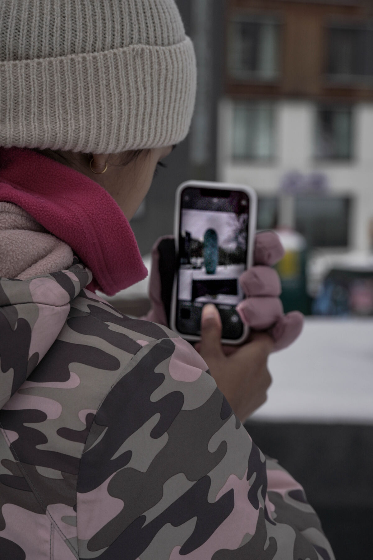 Barn står i en park og fotografer en kongleskulptur med mobiltelefonen. Foto.