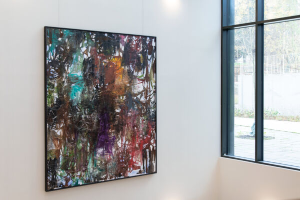 Foto av et fargerikt maleri hengende på en vegg i et stort, åpent rom på Lambertseterhjemmet.