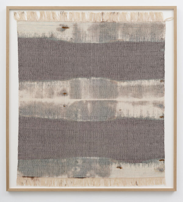 Foto av et kvadratisk tekstilverk, innrammet og hengende på en vegg.