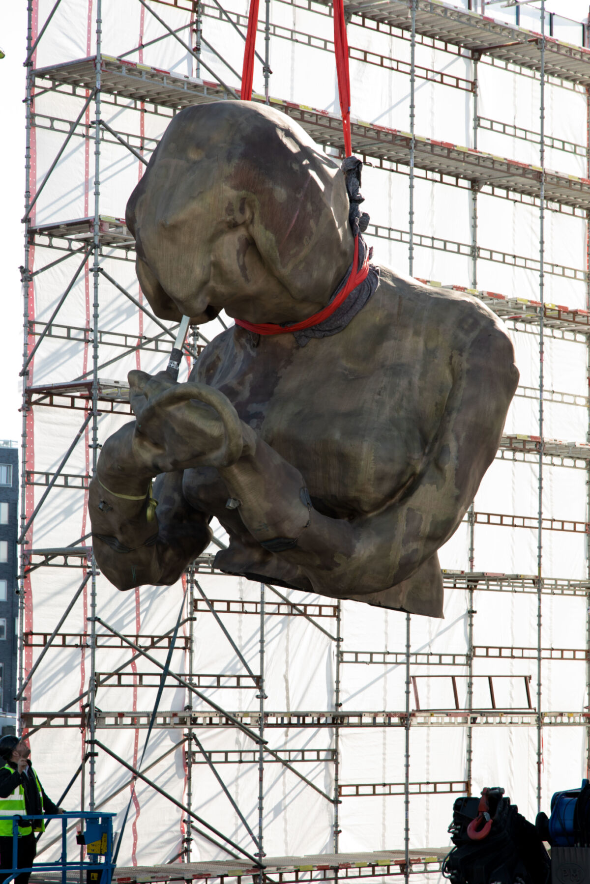 Del av skulptur løftes inn i stillas. Foto