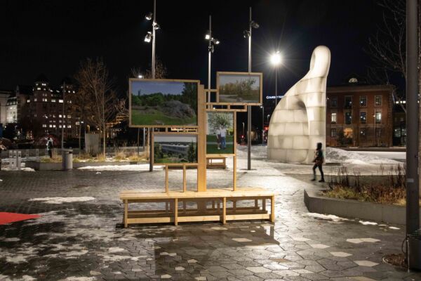 En fotoutstilling montert utendørs på et bytorg. Foto.