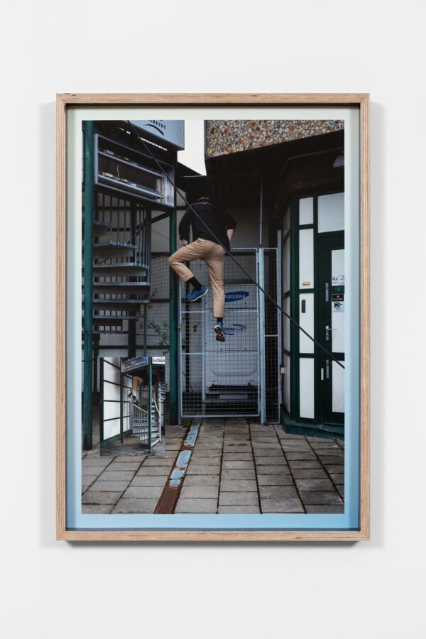 Person som klatrer på en gitterdør. Foto.