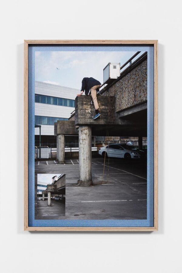 En person som klatrer på en betongbygning. Foto.