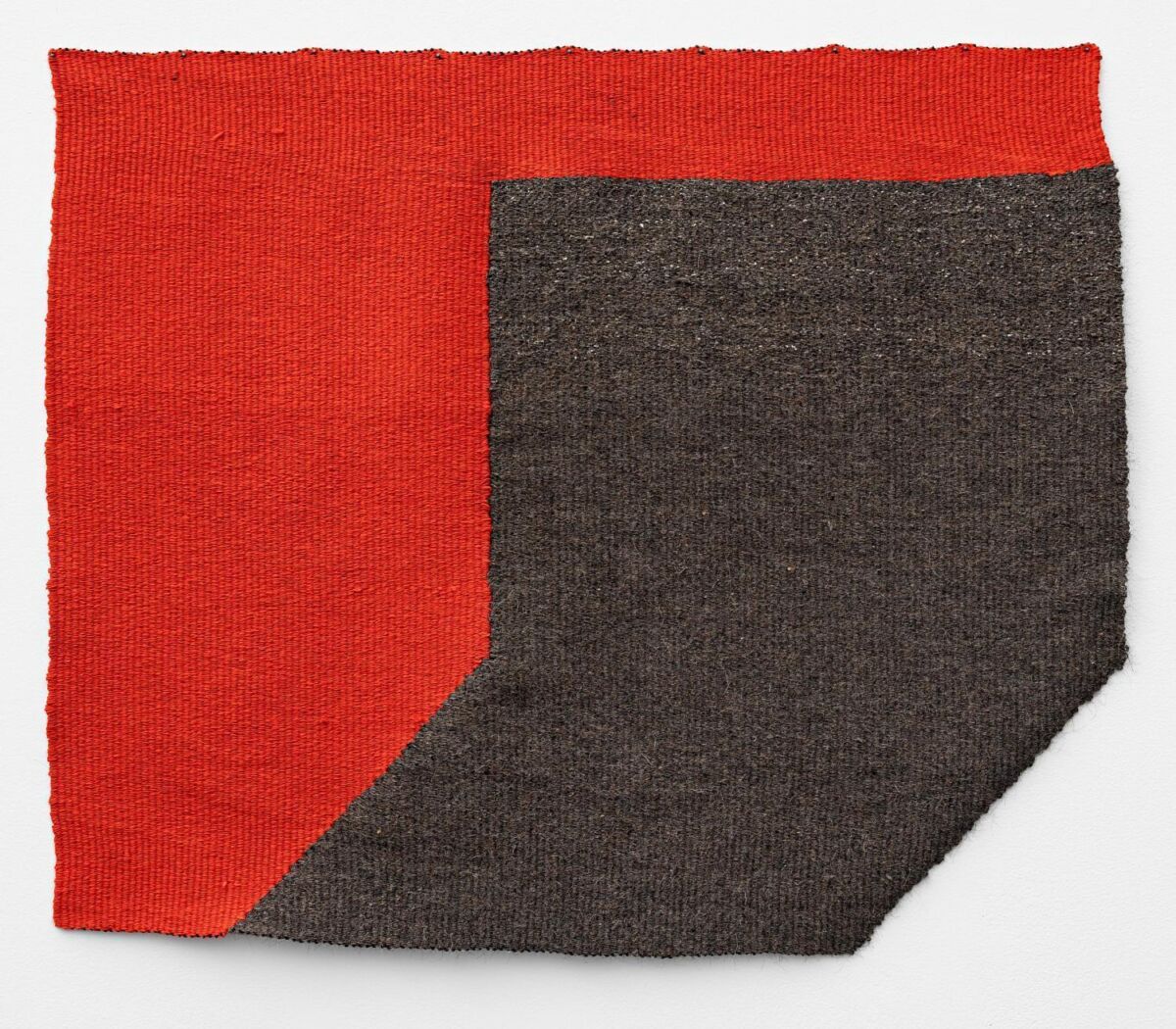 To vevde tøystykker satt sammen: Ett i rødt og ett i brunt. Foto av tekstil.