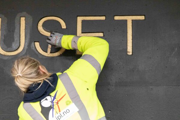 Person maler innendørs på en t-baneplattform. Foto.