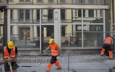 Bilde av anleggsarbeidere i en gate, Et kontorbygg i bakgrunnen. Foto