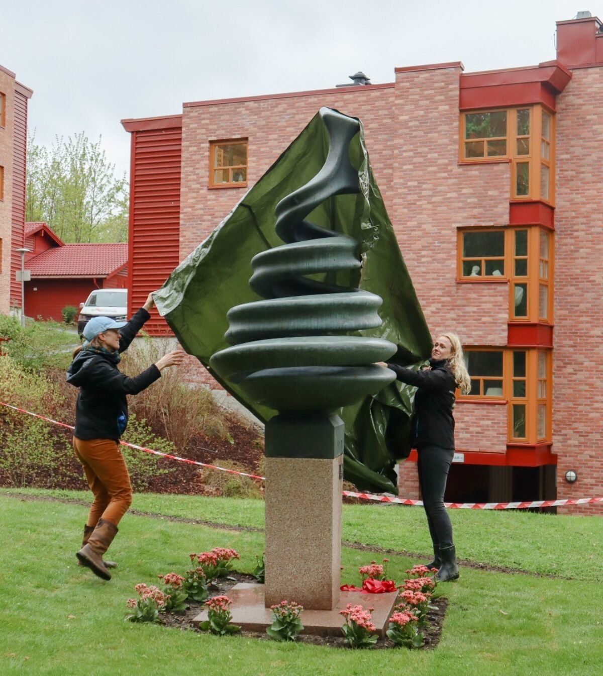 To personer avduker en skulptur. Foto.