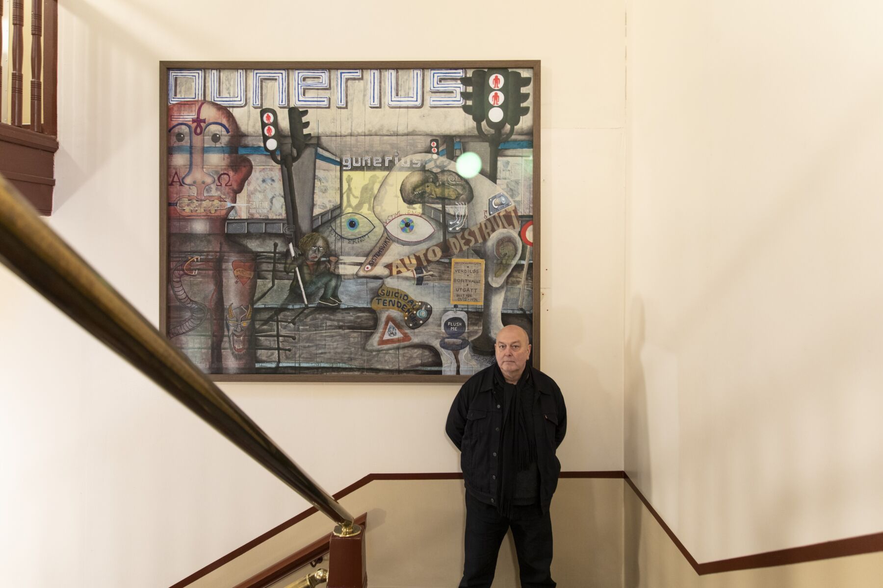 Person står i en trappegang foran et stort vegghengt maleri. Foto.