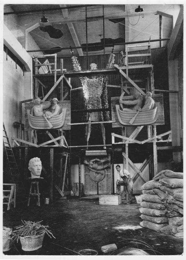 Svart-hvitt foto av arbeidet med St. Hallvard-skulpturgruppen i et stort verksted.