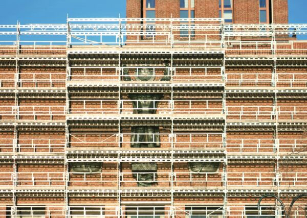 Foto av Rådhuset i Oslo tildekket av et stort stillas på sjøsiden.