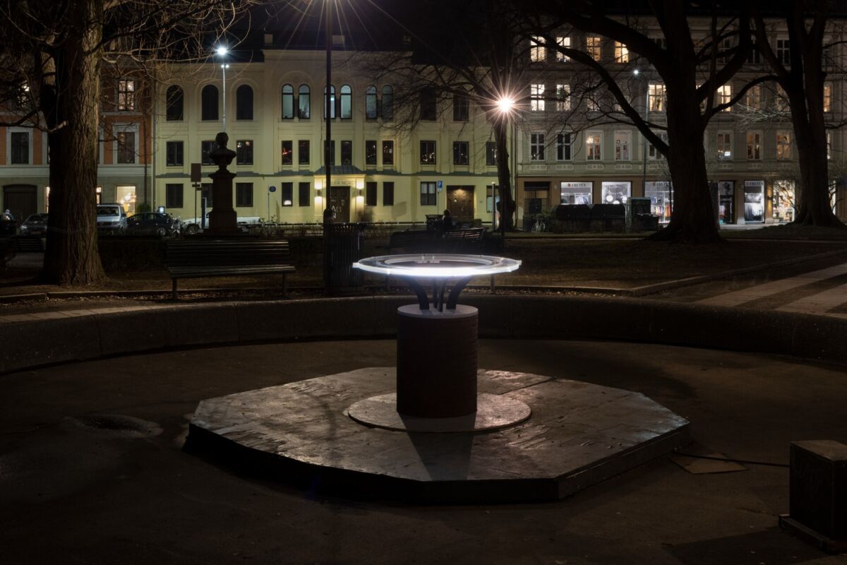 Utendørs kunstverk på et parktorg som lyser opp. Foto.