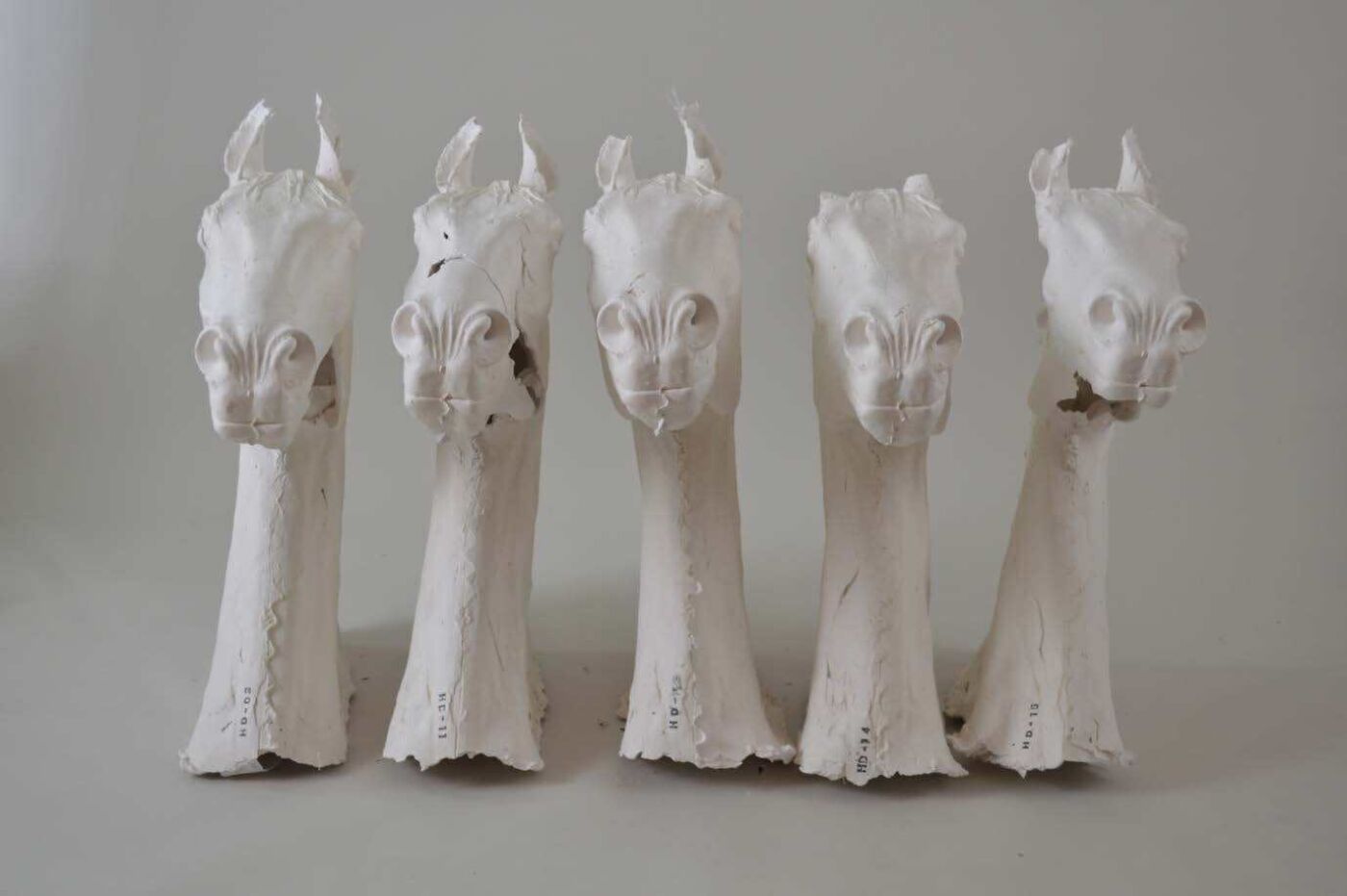 Fem hesteskulpturer i hvit farge. Foto.