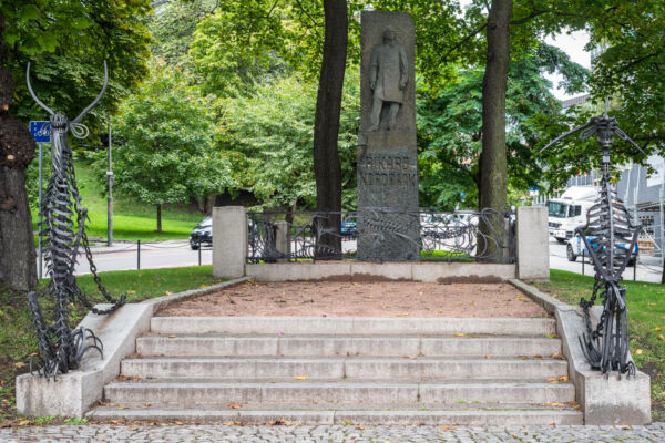 Skulptur med trapp og jerndekor foran. Foto.