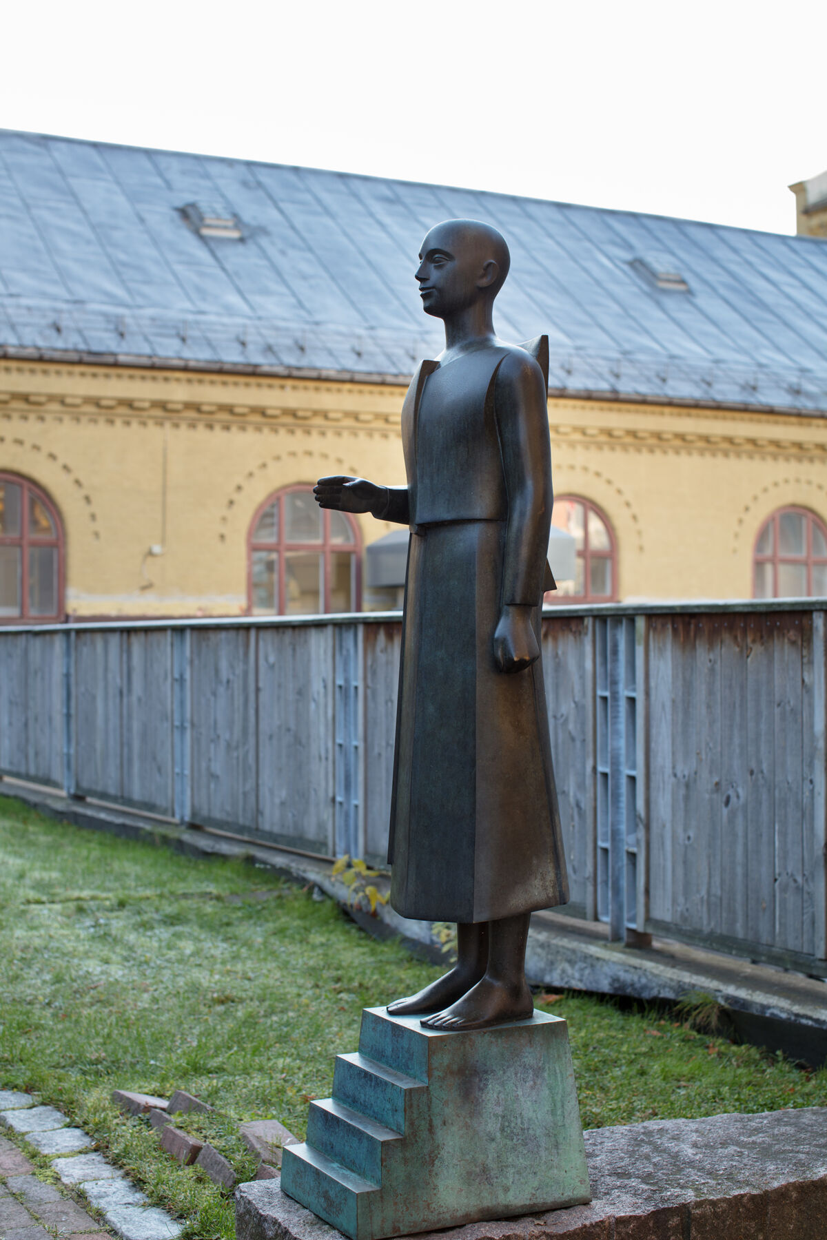 Skulptur av person i bronse som holder hånden ut. Skulpturen er laget av Istvan Lisztes. Foto.
