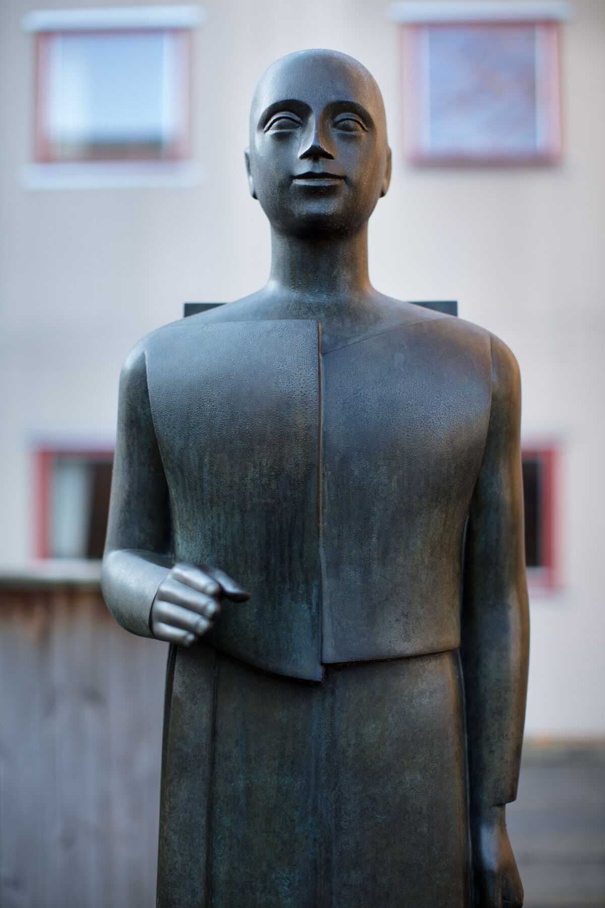 Skulptur av person i bronse som holder hånden ut. Skulpturen er laget av Istvan Lisztes. Foto.