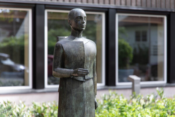 Skulptur av person i bronse som holder hånden ut. Skulpturen er laget av Istvan Lisztes. Foto